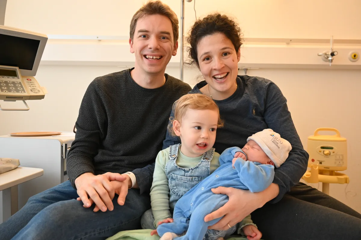 Eine Familie mit Mutter, Vater, Tochter und der frischgeborenen zweiten Tochter.